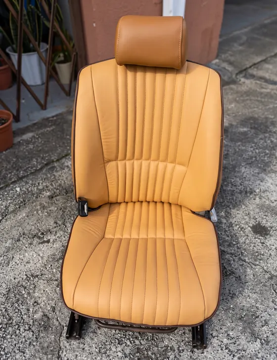 Asiento de auto clásico en piel color coñac con costura vertical