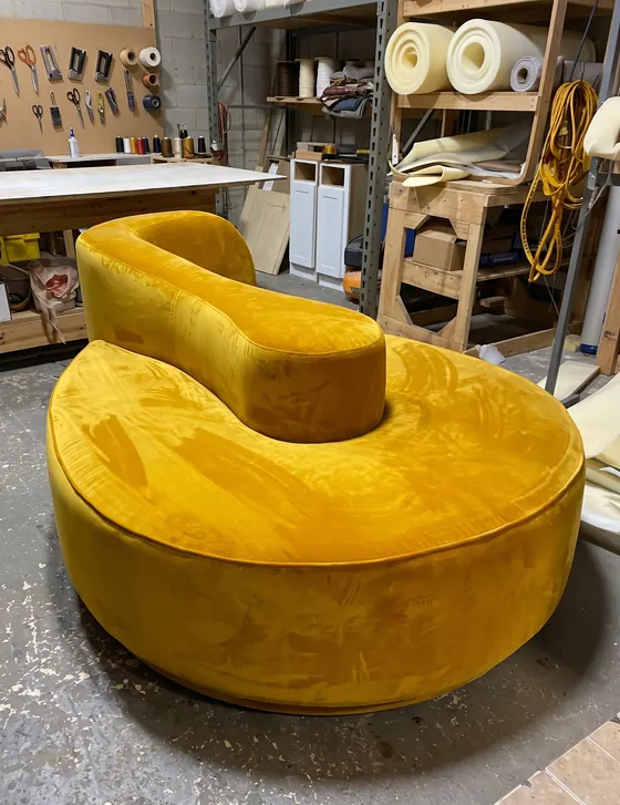Sofá curvo tapizado en terciopelo amarillo mostaza terminado