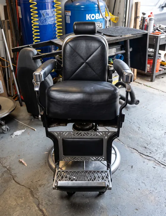 Silla de barbero retapizada en vinil negro con costura en X