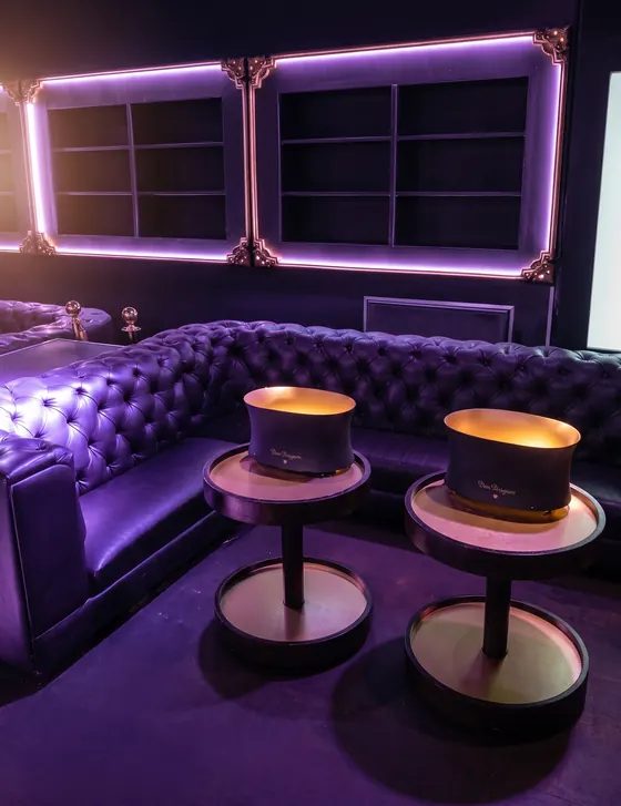 Sofá chesterfield morado para lounge con luces de neón
