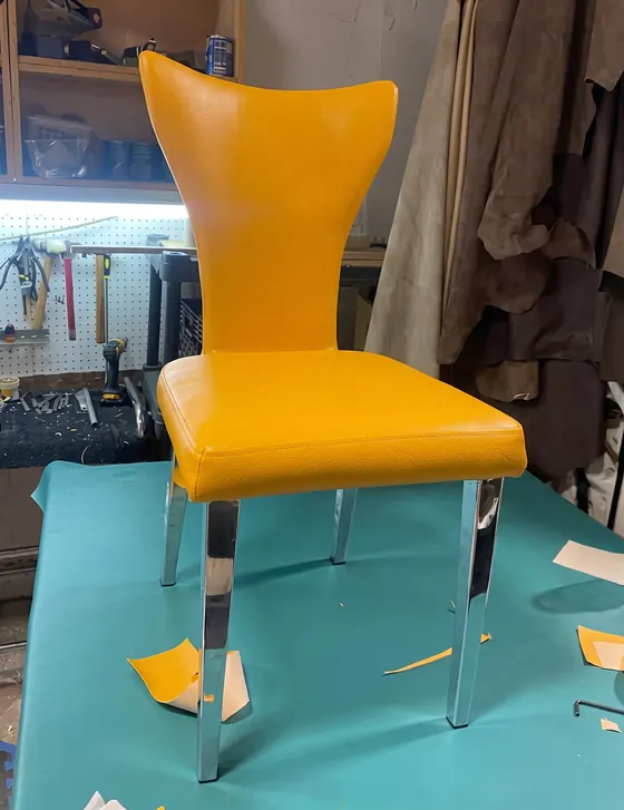 Silla de diseño tapizada en vinil amarillo sobre la mesa de trabajo