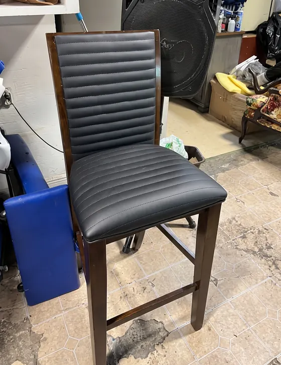 Silla de bar tapizada en negro con respaldo acanalado