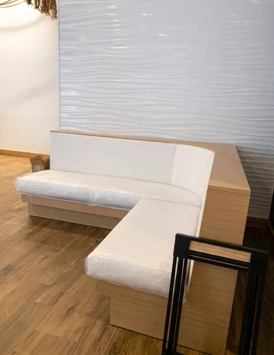 Banqueta en L tapizada en blanco para un espacio interior