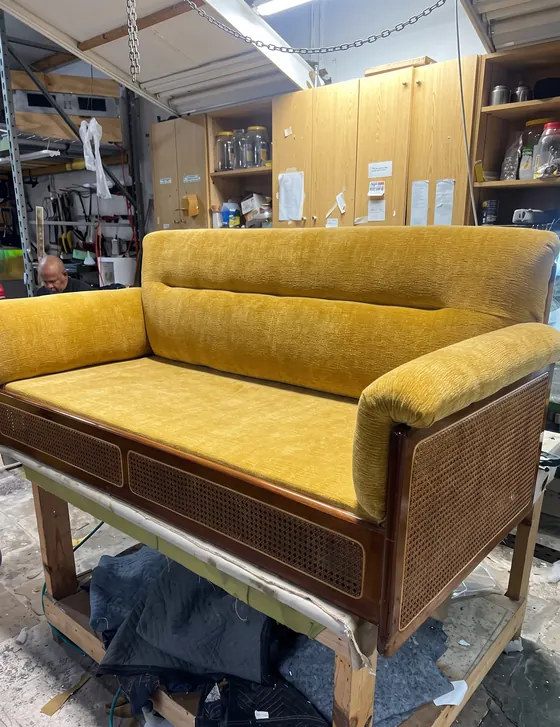 Loveseat de madera y rejilla con cojines en terciopelo mostaza