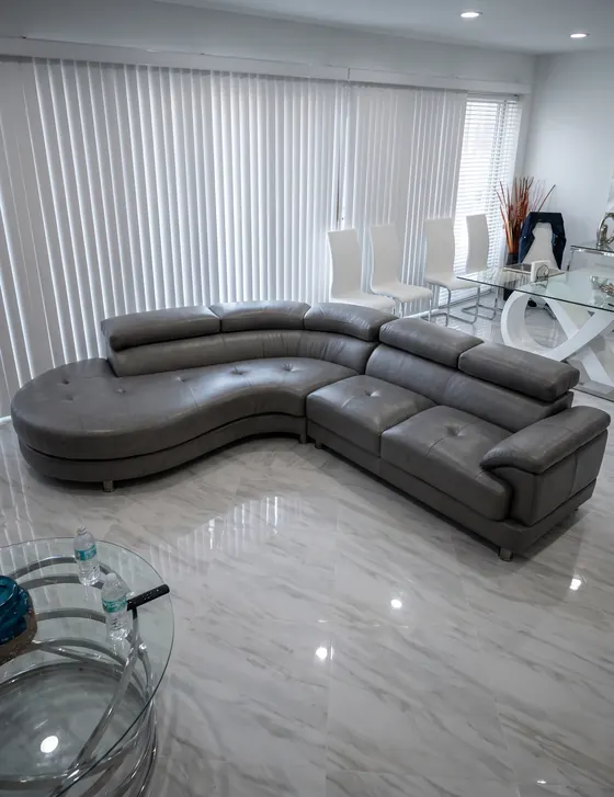 Seccional curvo gris con reposacabezas ajustables en una sala moderna